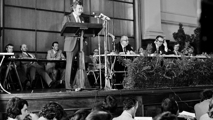 Bob Hawk standing at a lectern addressing the Biennial Congress of Trade Unions in 1975.