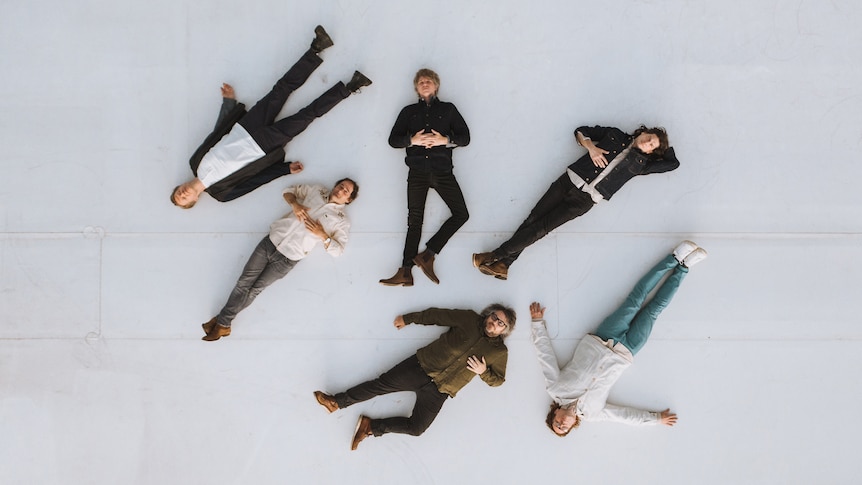 The six members of Wilco laid out in random shapes on a floor
