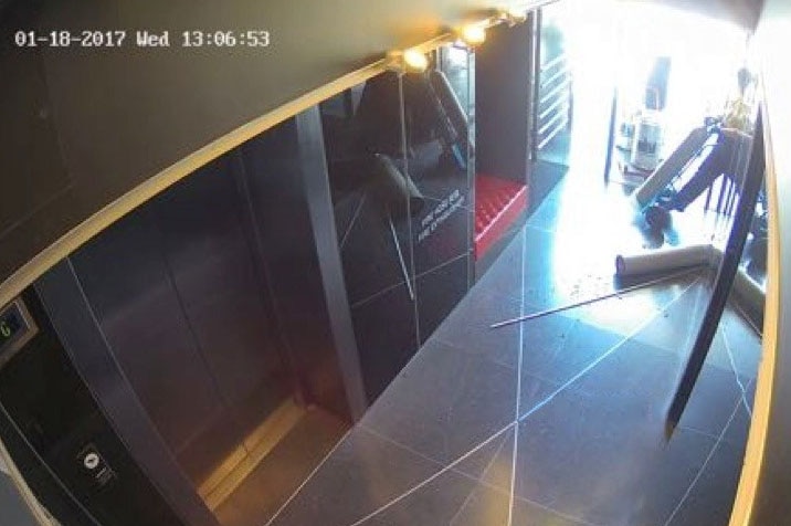 A gas cylinder smashing an apartment foyer window.