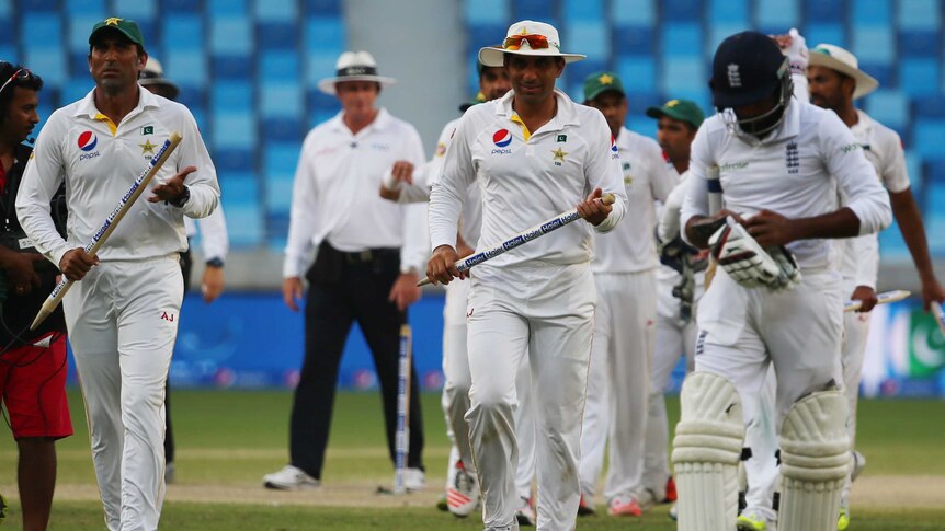Pakistan and England players walk off after the second Test at Dubai Stadium