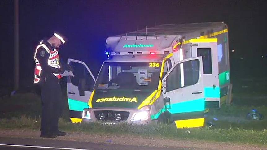 A damaged ambulance off the side of the road after it rolled