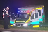 A damaged ambulance off the side of the road after it rolled