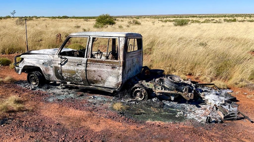A 4WD vehicle gutted by car sits abandoned on a grassy bush track