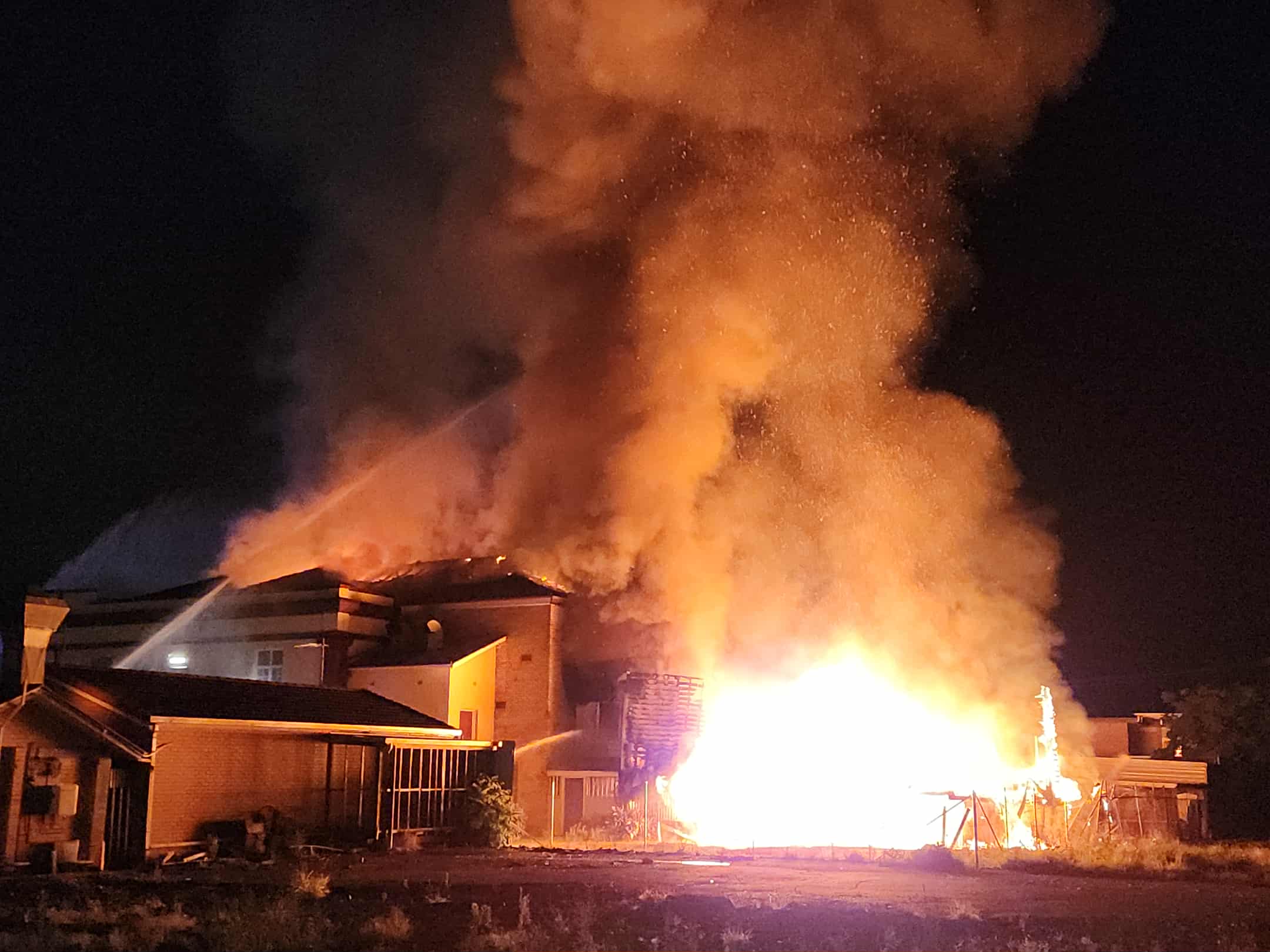 Un incendie rugissant avec de la fumée et du feu alors qu'un bâtiment brûle.