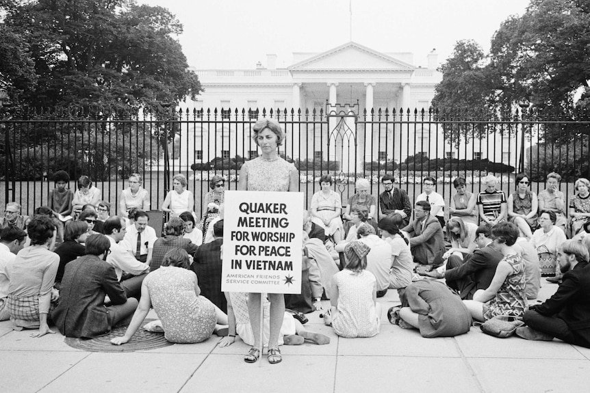 Quakers holding a 'meeting of worship' with placards outside the White House to protest the Vietnam War.