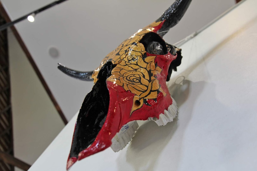 A cow skull painted with golden roses