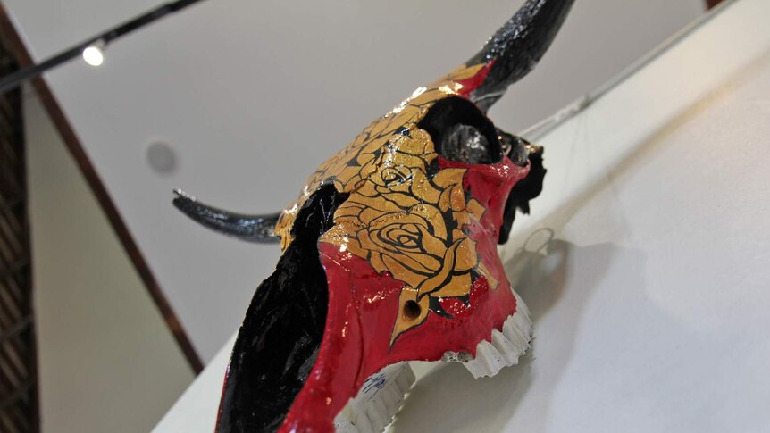 A cow skull painted with golden roses