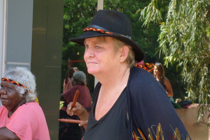 Image of a middle-aged woman in a black hat and black t-shirt standing outside the Kununurra Magistrate's Court.