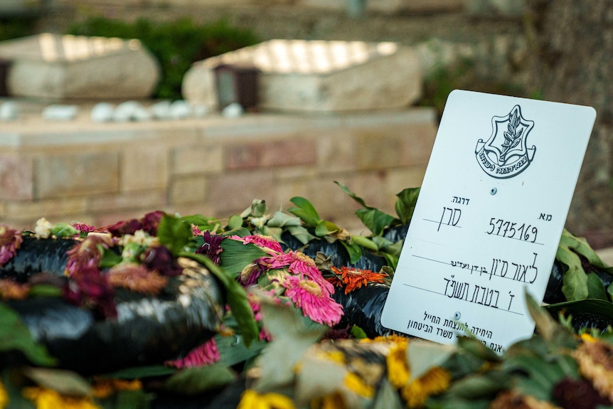 墓地上摆放的鲜花以及希伯来文卡片