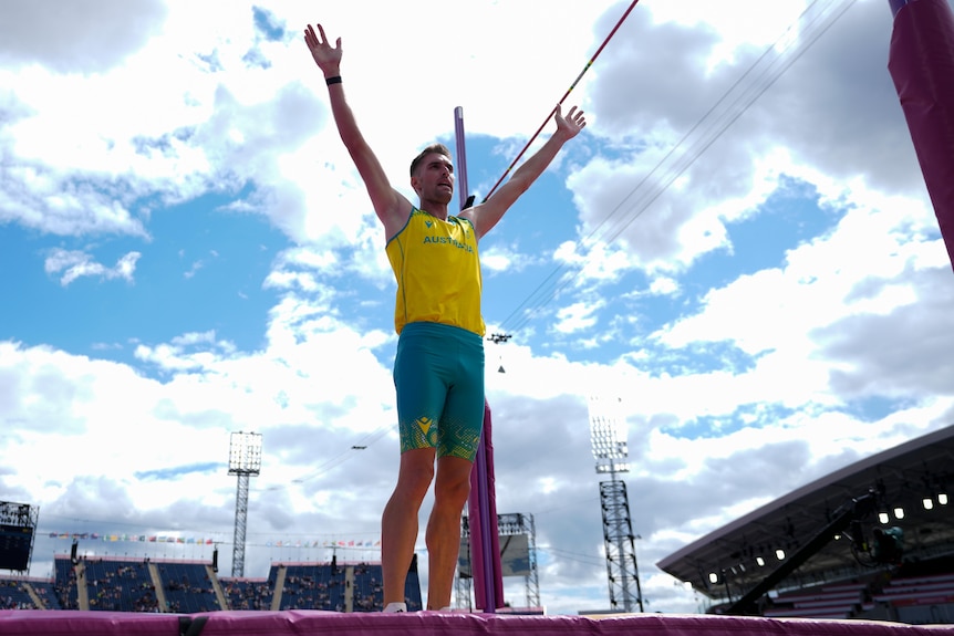 Cedric Dubler raises both hands after the pole vault in the decathlon at the Commonwealth Games.