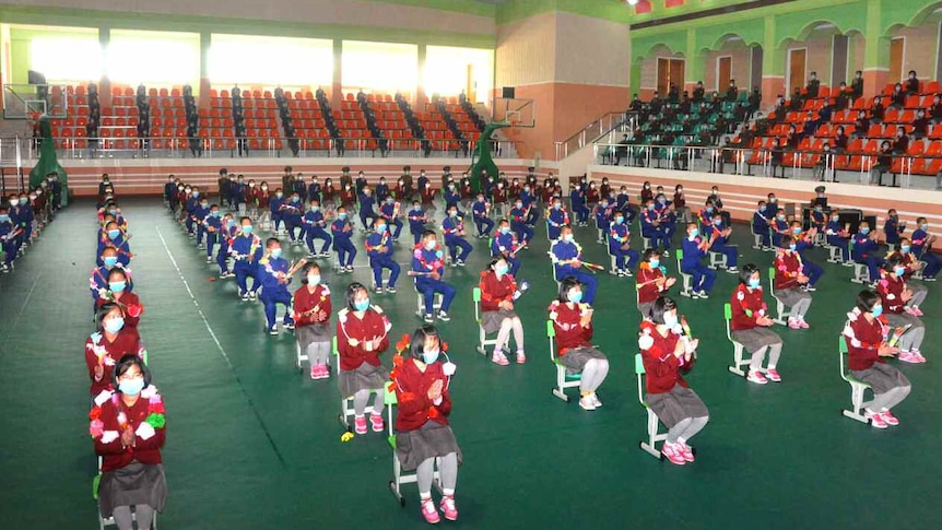 Children lined up in what appears to be hall in North Korea