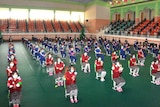 Children lined up in what appears to be hall in North Korea