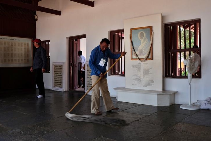 A man mops the floor inside Ghandi Ashram where Trump is expected to visit.