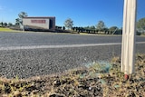 Glass on ground with Maryborough town sign in background