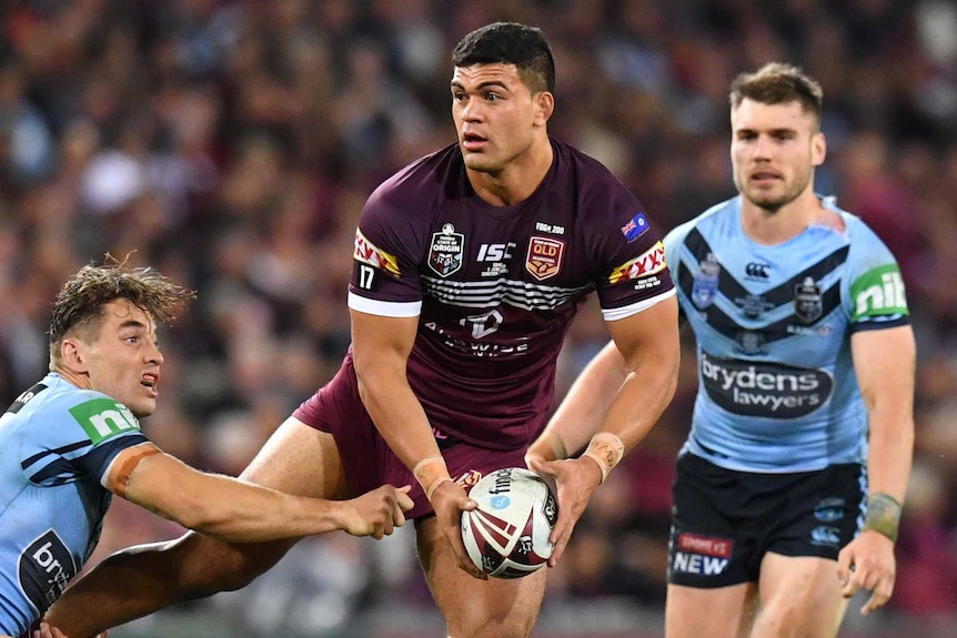 David Fifita looks to offload for the Queensland Maroons during a tackle by the NSW Blues' Cameron Murray in State of Origin I.