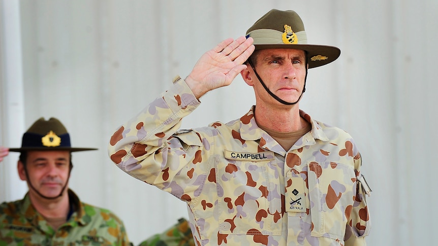 Major General Angus Campbell accepts a salute during the transition parade at Al Minhad Airbase, United Arab Emirates.