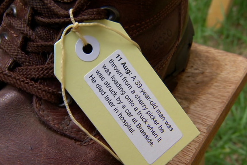 A shoe with a tag on it describing the circumstances of a worker's death.
