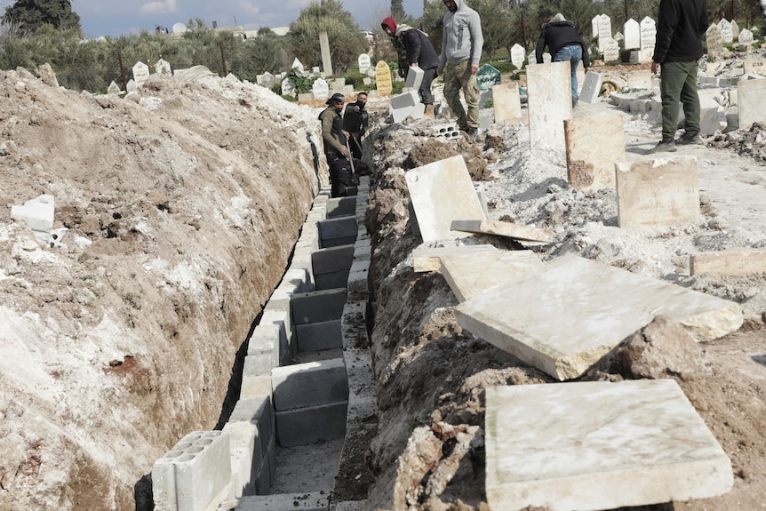 Volunteers prepare graves for the casualties, in the aftermath of a deadly earthquake.