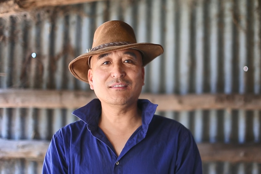 A man wearing a blue shirt and an an Akubra.