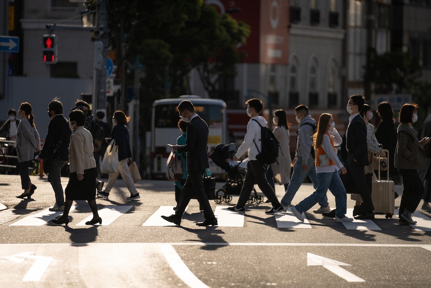 A crowded Japanese crossing in glowing afternoon sunlight 