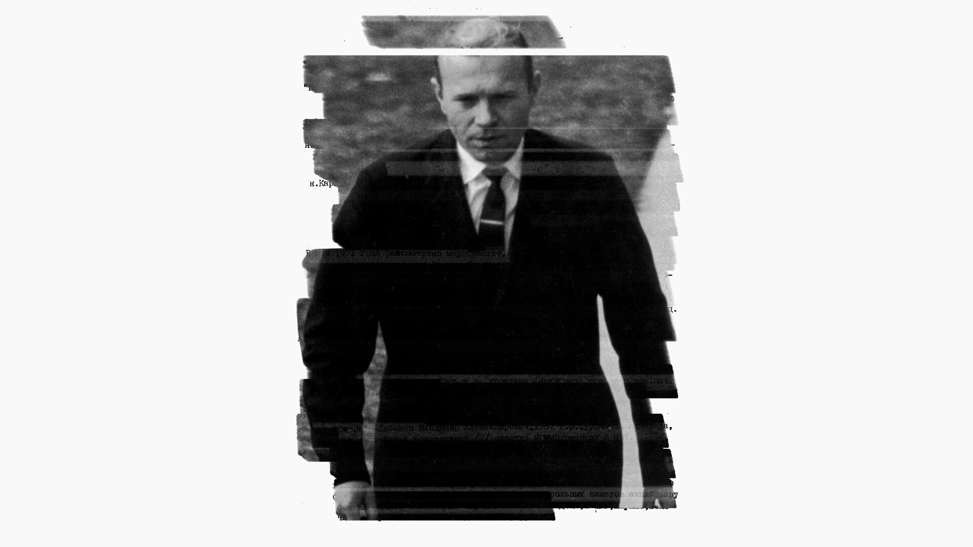 A black and white photo of a man in a dark suit and tie walking.