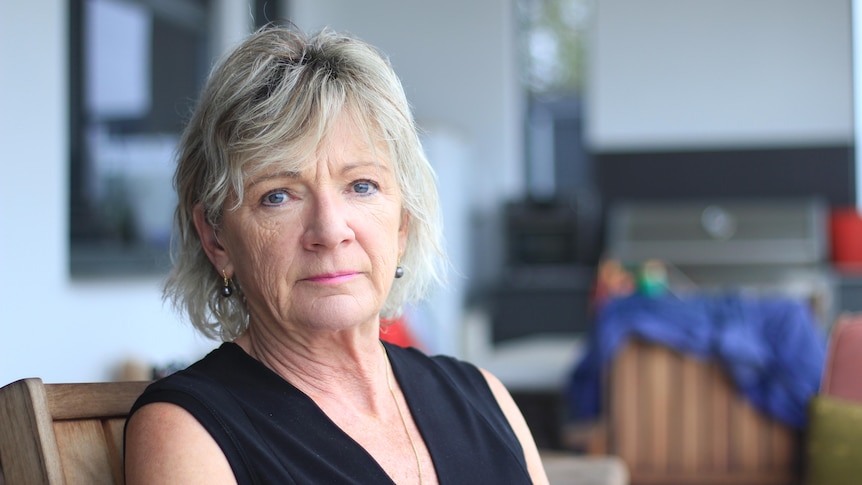 A woman in her early 60's with blonde hair  has a serious expression, it's a portrait shot.