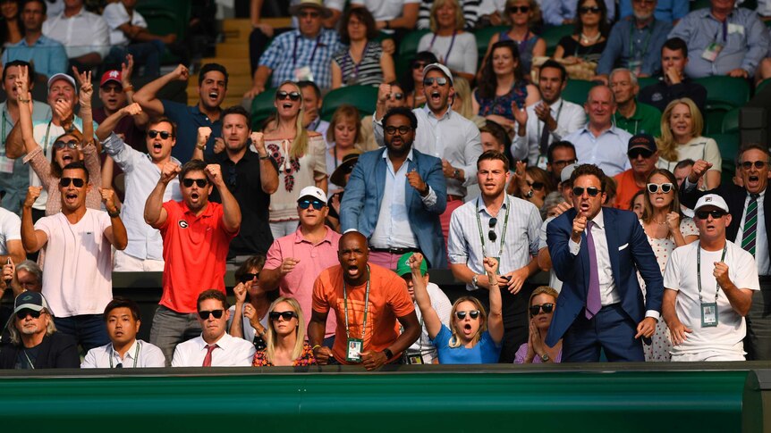 Spectators cheer during Wimbledon men's singles semi-final between Kevin Anderson and John Isner.