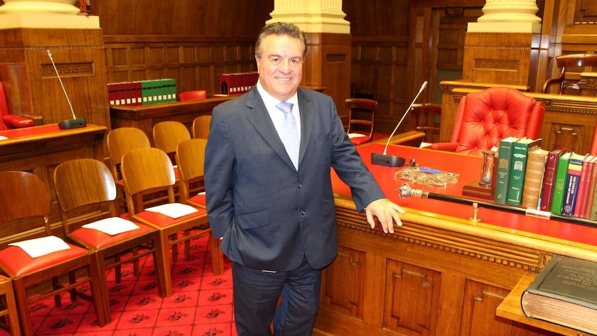 A man in a suit standing in parliament