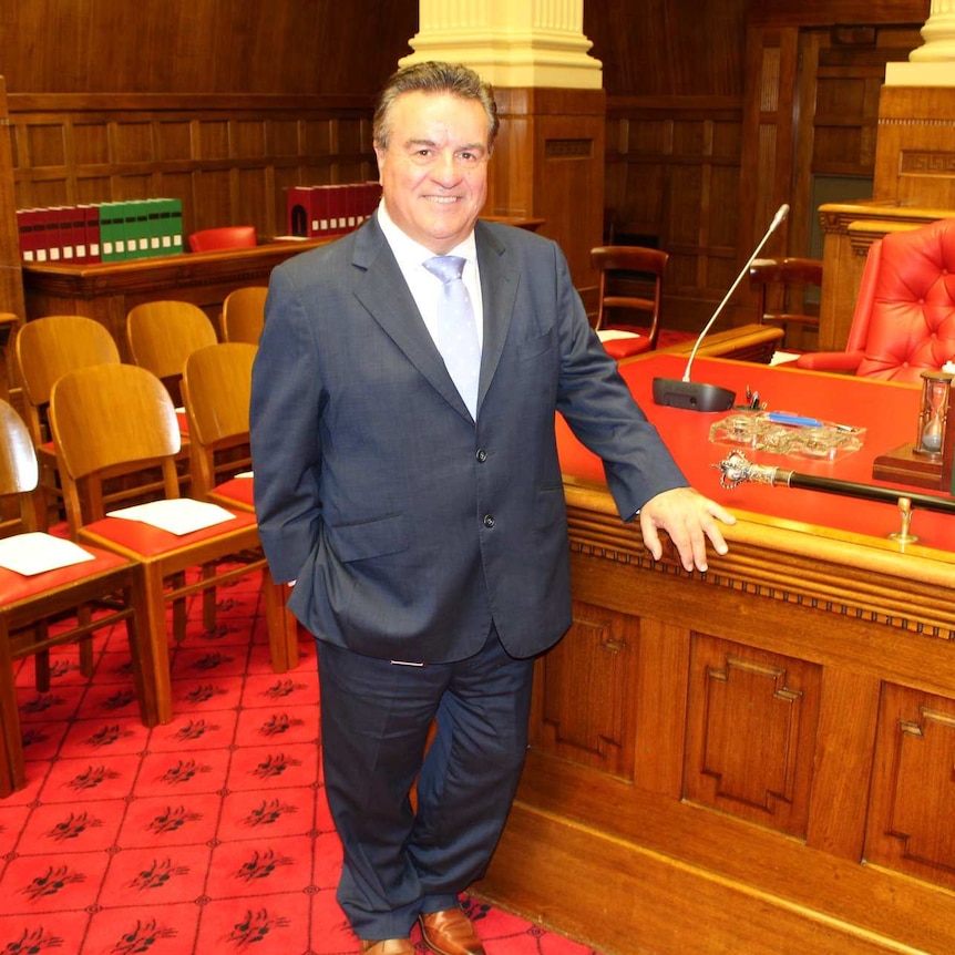 A man in a suit standing in parliament