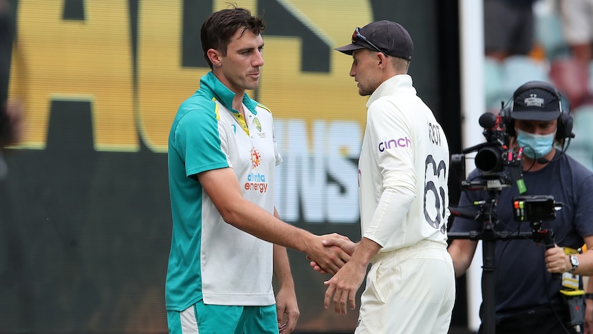 Pat Cummins shakes hands with Joe Root after Australia won on day four of the First Ashes Test 