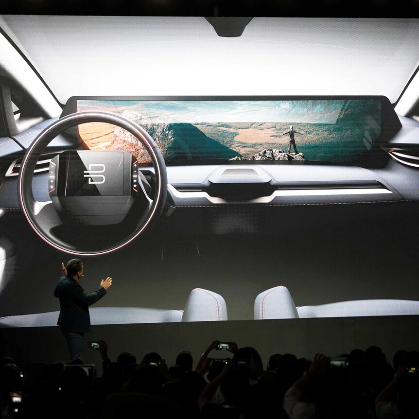 A man gestures to a concept of the Byton Car, an electric semi-autonomous car announced at CES 2018