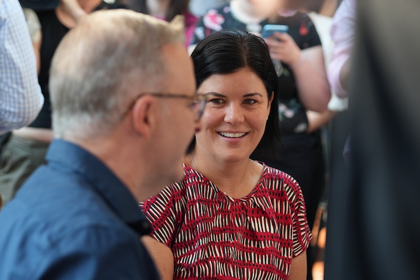 A woman with short dark hair smiles at Labor leader Anthony Albanese.