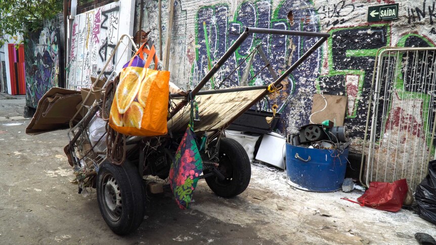 A carrocas, or cart, with rubbish on it and bags hanging from it, on a street in Sao Paulo.