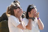 Two woman crying after being evacuated from a fire zone