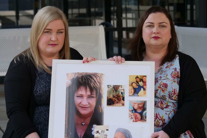 Nicole Robertson and Jacqui Hicks hold a frame containing photos of their mother.