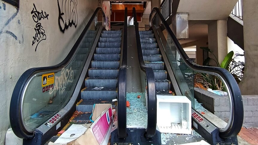 A broken escalator with rubbish.