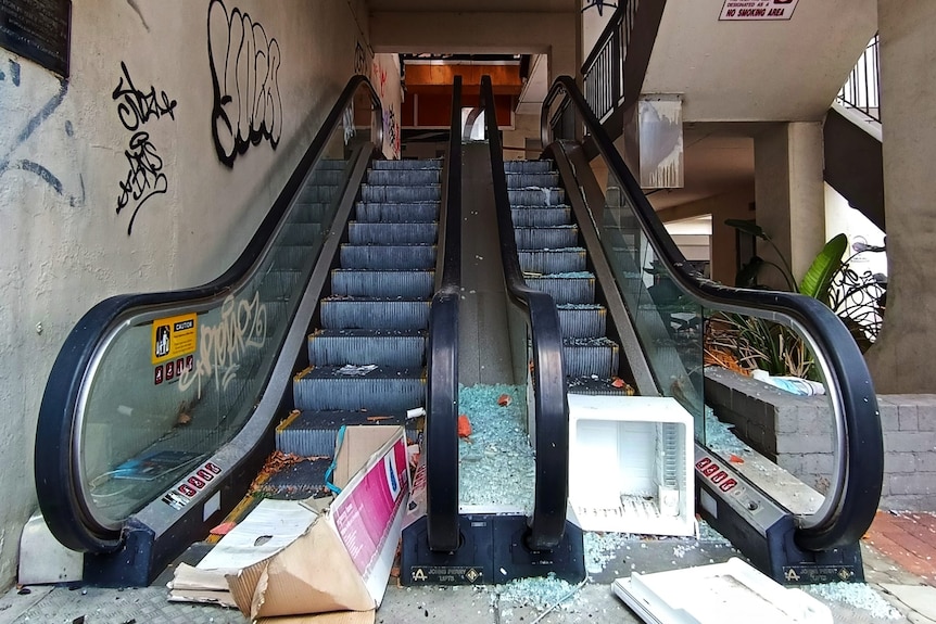 A broken escalator with rubbish.
