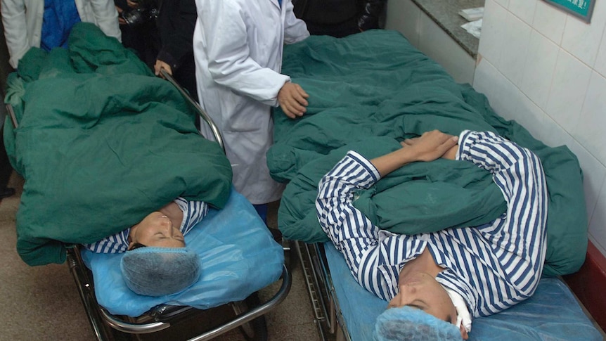 Zhang Xiuping (L) and her son Lin Dawei lie on beds next to each other before their operation at a hospital in Hefei, Anhui province on December 15, 2007.