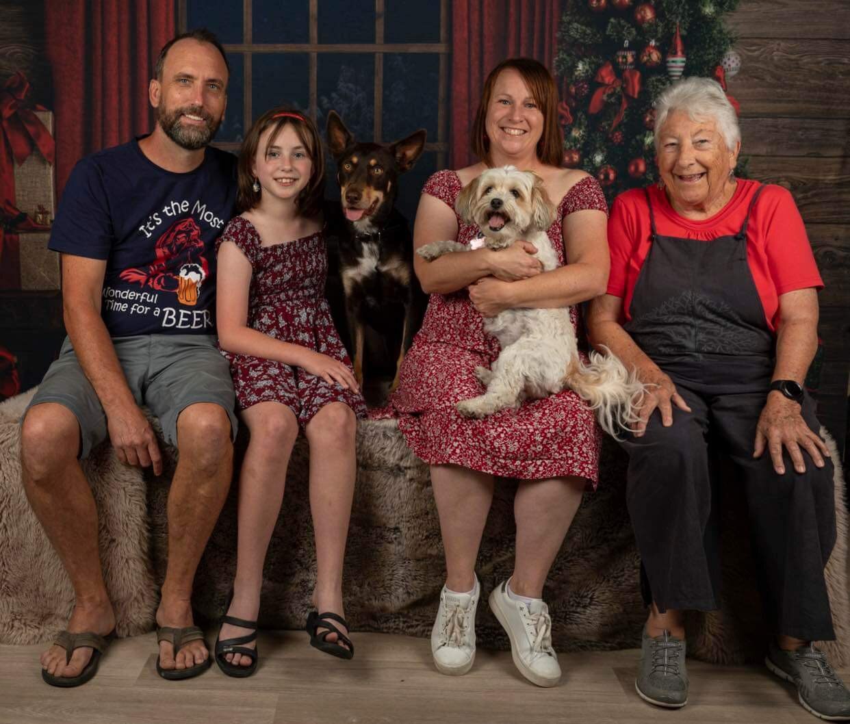 three adults, a child and two dogs pose for a santa photo