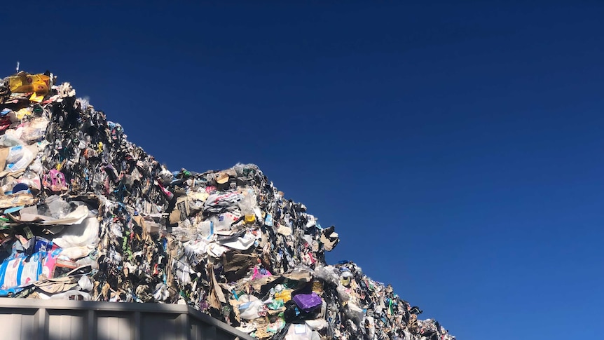 Bales of recycling piled up behind a fence in Tasmania.