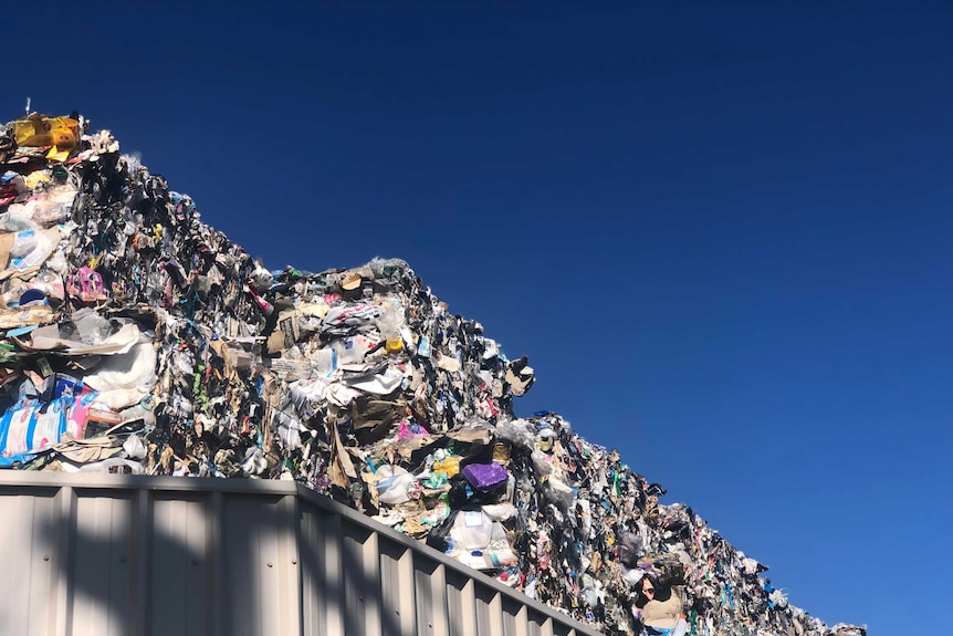 Bales of recycling piled up behind a fence in Tasmania.