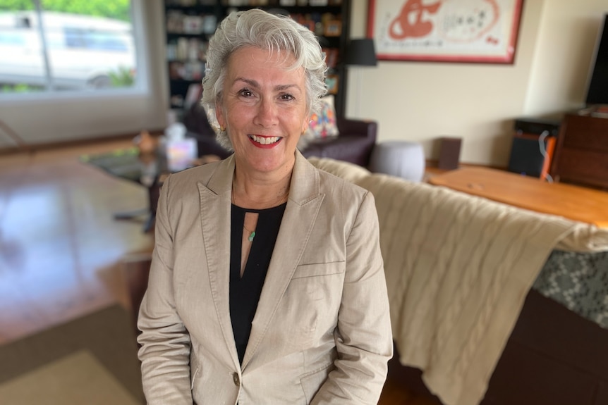 A woman in a cream suit in a home environment