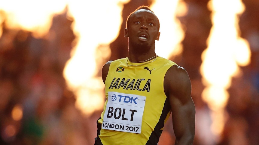 Usain Bolt looks disappointed as flames shoot up behind him.