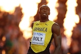 Usain Bolt looks disappointed as flames shoot up behind him.