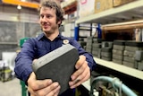 MGA Thermal's Alex Post holds one of its heat storing bricks in his hands in a workshop.