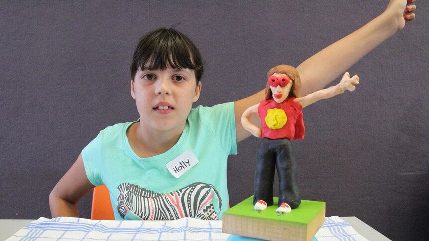 Young artist Holly with superhero sculpture
