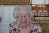 Queen Elizabeth II smiles on a Zoom video call.