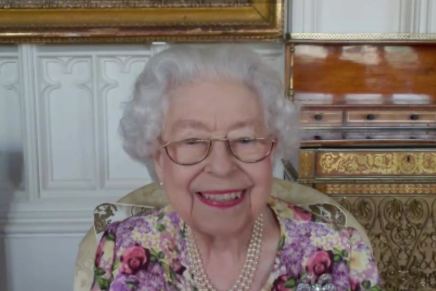 Queen Elizabeth II smiles on a Zoom video call.