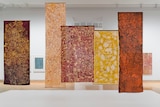 Large, earth coloured batiks by artist Emily Kam Kngwarray hang from the ceiling in the NGA