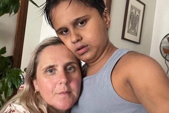 A blonde woman and her son in a selfie, looking at the camera. 